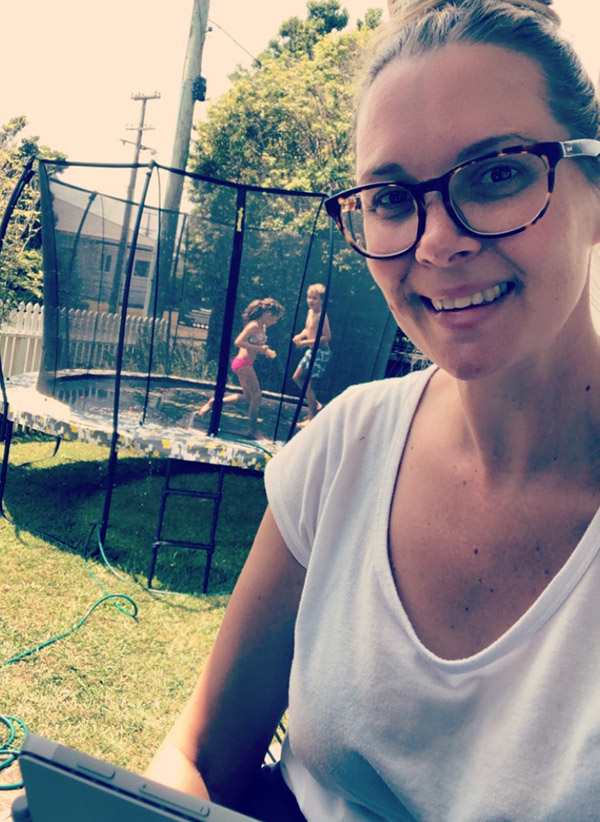 Diversity Manager Claire Stuart works from home while her children Zoe and Micah cool off on the trampoline