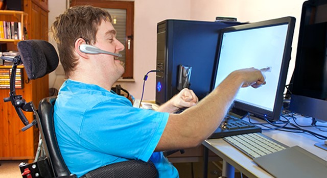 Young disabled man using touch screen to work