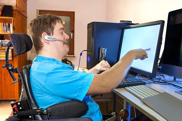Young disabled man uses touch screen for work